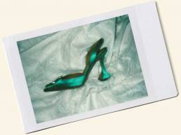 Polaroid of an emerald Amina Muaddi shoe